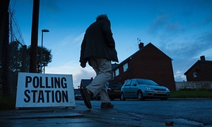 Man walking past polling station sign