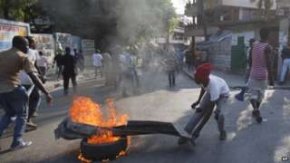 Protesters set a tyre on fire in Port-au-Prince. Photo: 23 January 2015