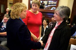 Republican Cathy Manchester (left) and Democrat Catherine Breen (right) shake hands while former lawmaker Meredith Strang Burgess smiles at them before a committee hearing on the Senate District 25 ballot issue on Tuesday at the State House in Augusta. Troy R. Bennett | BDN